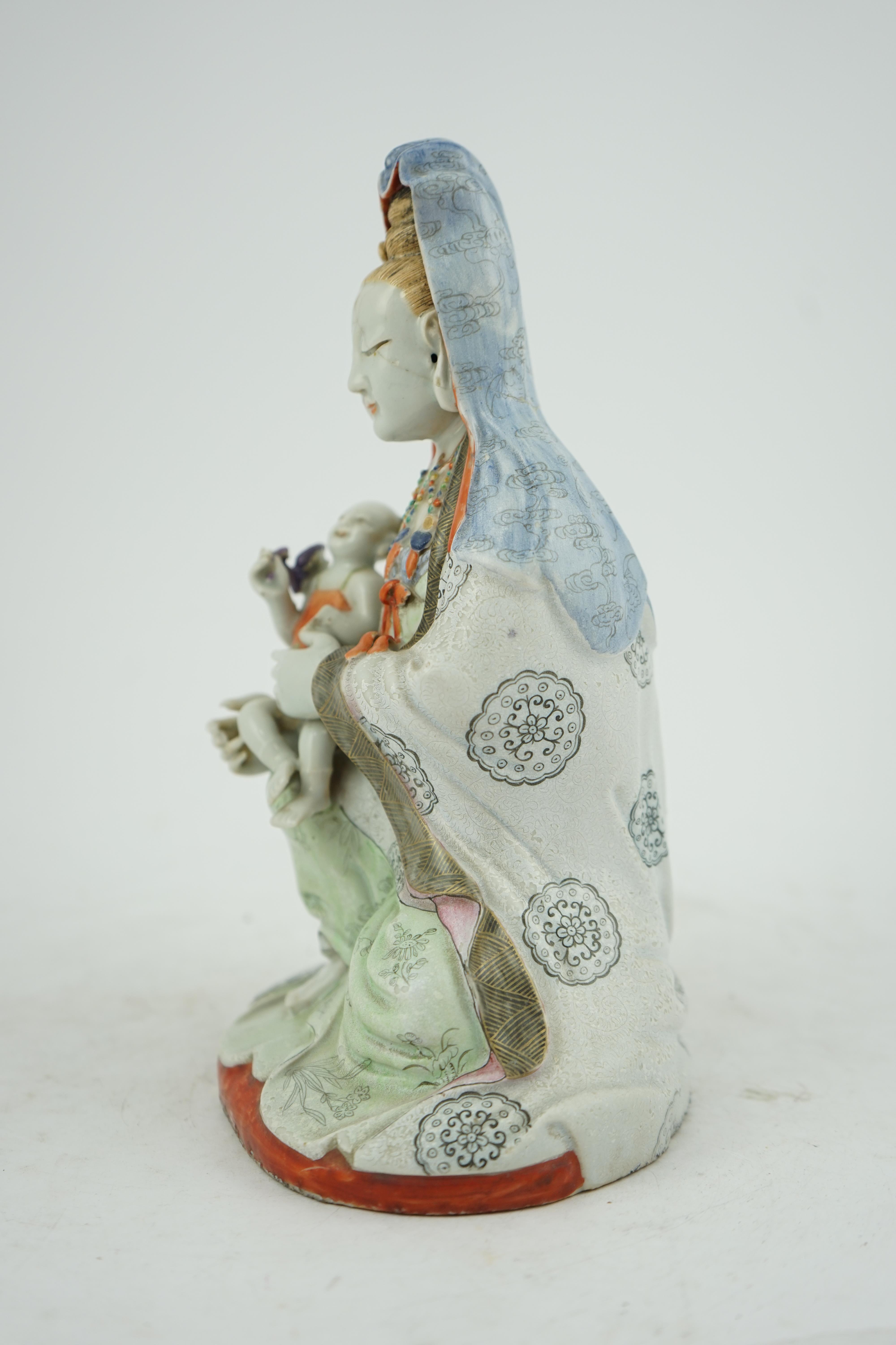 A Chinese enamelled porcelain group of Guanyin holding a child, Qianlong period